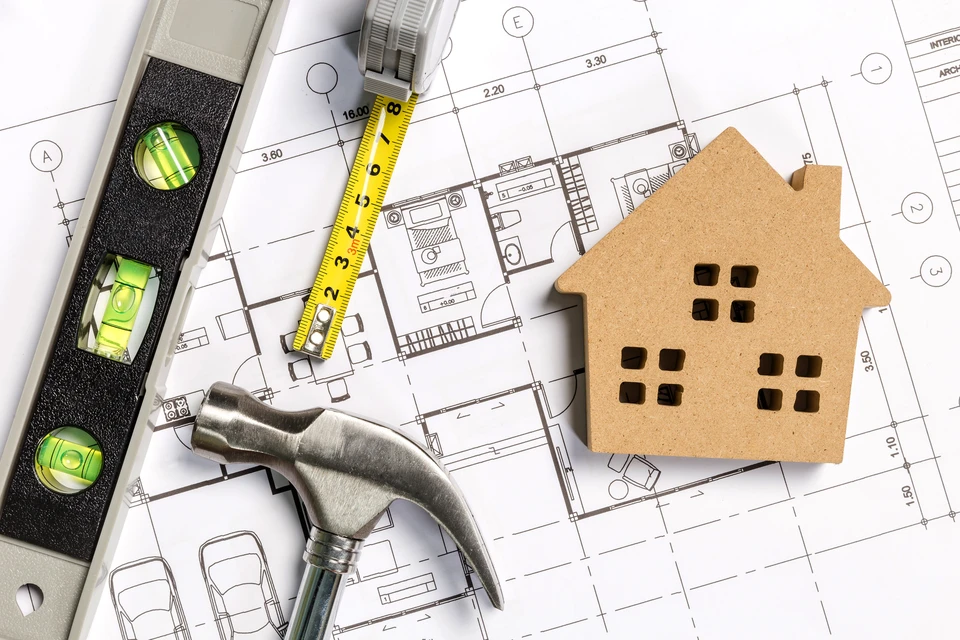Plans d'architecture techniques avec outils de construction professionnels disposés sur surface de travail